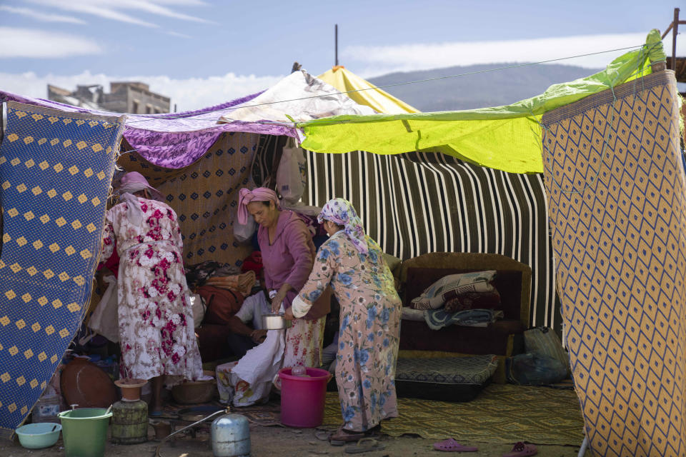 Women cook inside a tent after they were displaced by the earthquake, in the town of Amizmiz, near Marrakech, Morocco, Sunday, Sept. 10, 2023. An aftershock rattled Moroccans on Sunday as they prayed for victims of the nation’s strongest earthquake in more than a century and toiled to rescue survivors while soldiers and workers brought water and supplies to desperate mountain villages in ruins. (AP Photo/Mosa'ab Elshamy)