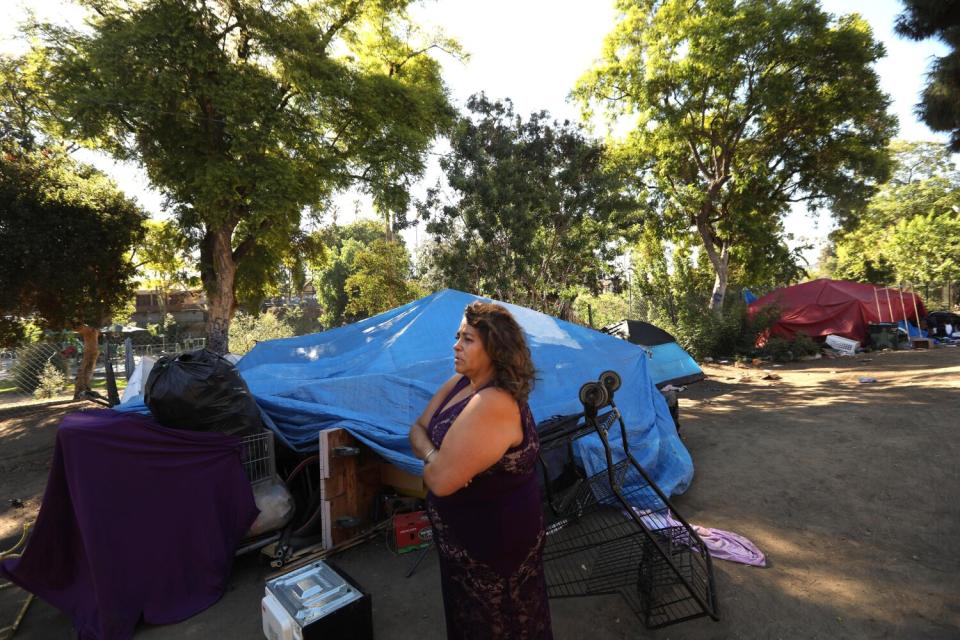 Maria Hernandez stands next to her tent where she lives in Hollenbeck Park in Boyle Heights.