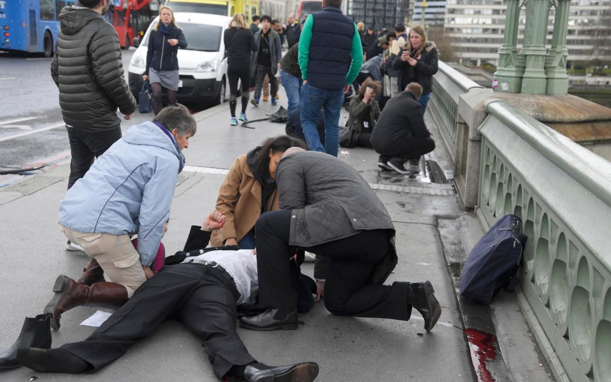 Victims of Wednesday's terror attack receive treatment from passers by on Westminster Bridge - REUTERS