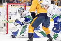 Vancouver Canucks goaltender Arturs Silovs (31) dives onto the puck as it slides toward the goal during the second period during Game 4 against the Nashville Predators in an NHL hockey Stanley Cup first-round playoff series Sunday, April 28, 2024, in Nashville, Tenn. (AP Photo/George Walker IV)
