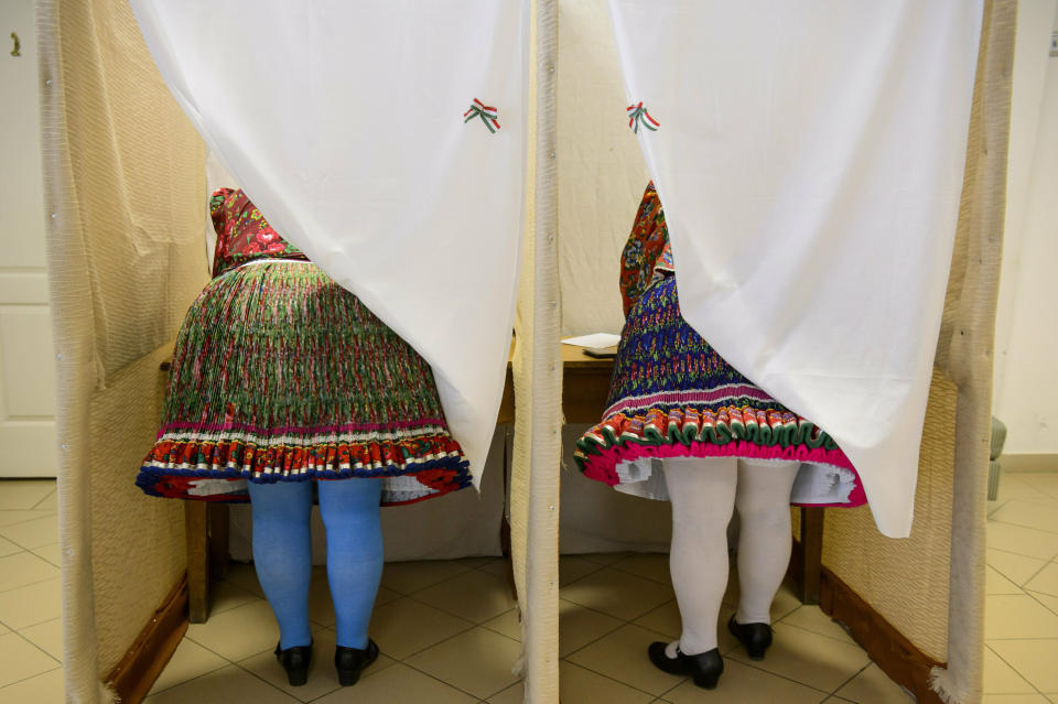 Women wearing folk costumes cast their vote during the European elections in a polling station in Bujak, Hungary, Sunday, May 26, 2019. The European Parliament election is held by member countries of the European Union (EU) from May 23 to 26, 2019. (Peter Komka/MTI via AP)