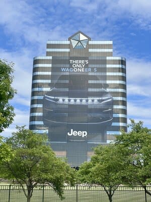 A building wrap of the all-new, all-electric 2024 Jeep® Wagoneer S Launch Edition, measuring over 15,000 square feet and 10 floors, appears on the tower at Stellantis North America headquarters in Auburn Hills, Michigan.