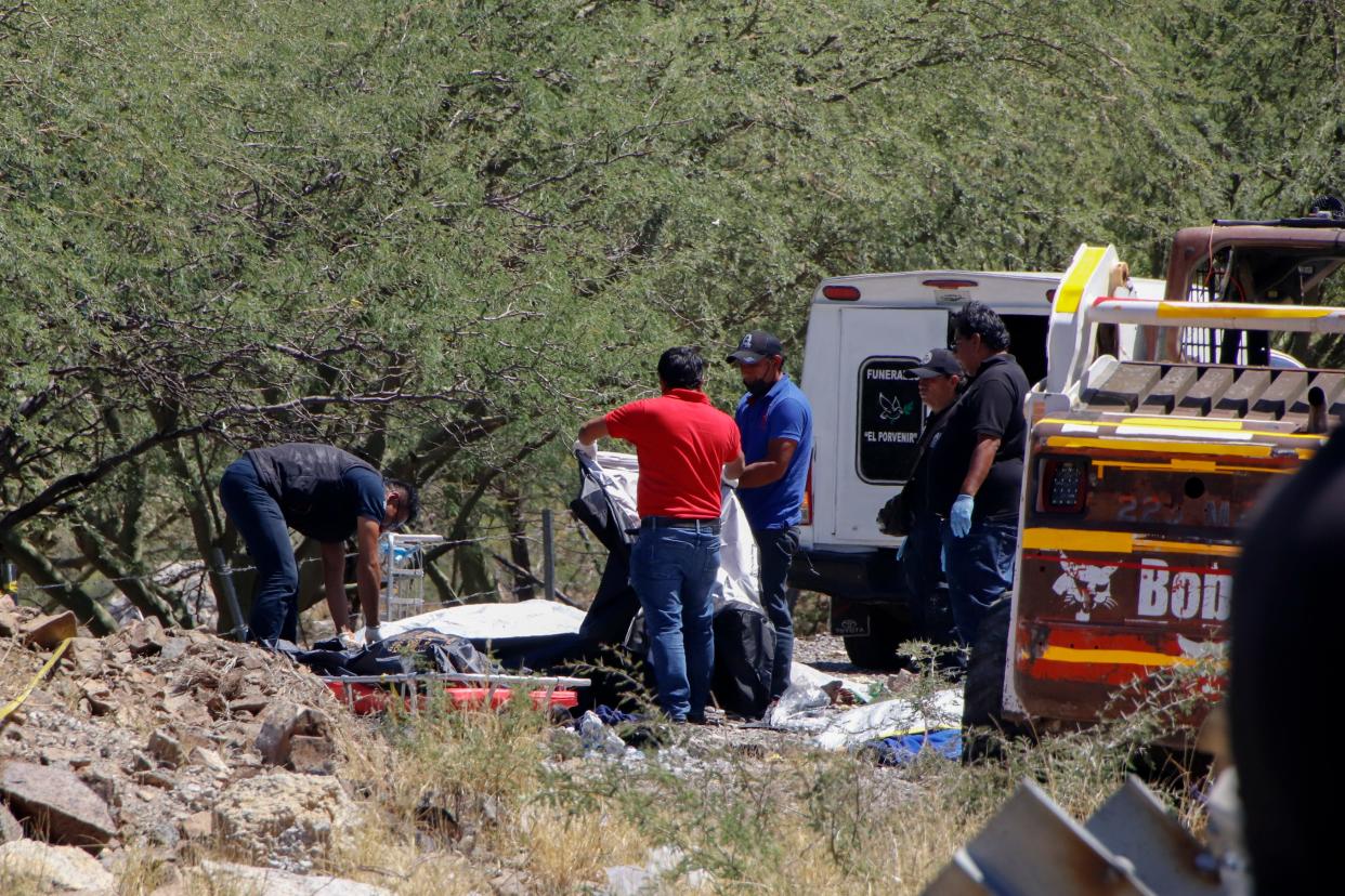 Forensics work over bodies at the scene of a bus accident on the side of the road near Villa de Tepelmeme, Oaxaca state, Mexico, on Oct. 6, 2023. At least 18 migrants from Venezuela and Peru died in the bus crash, authorities said.