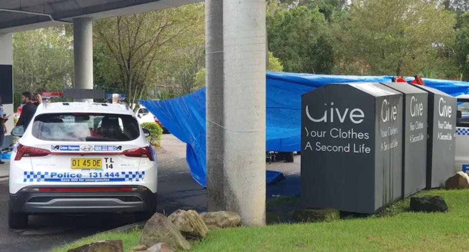 Police car and charity bins at Westfield Tuggerah car park. 