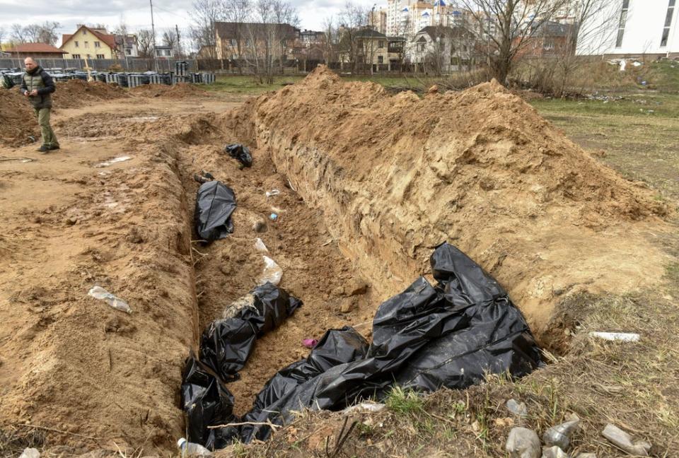 Bodies of civilians in plastic bags lay in a mass grave in Bucha (EPA)