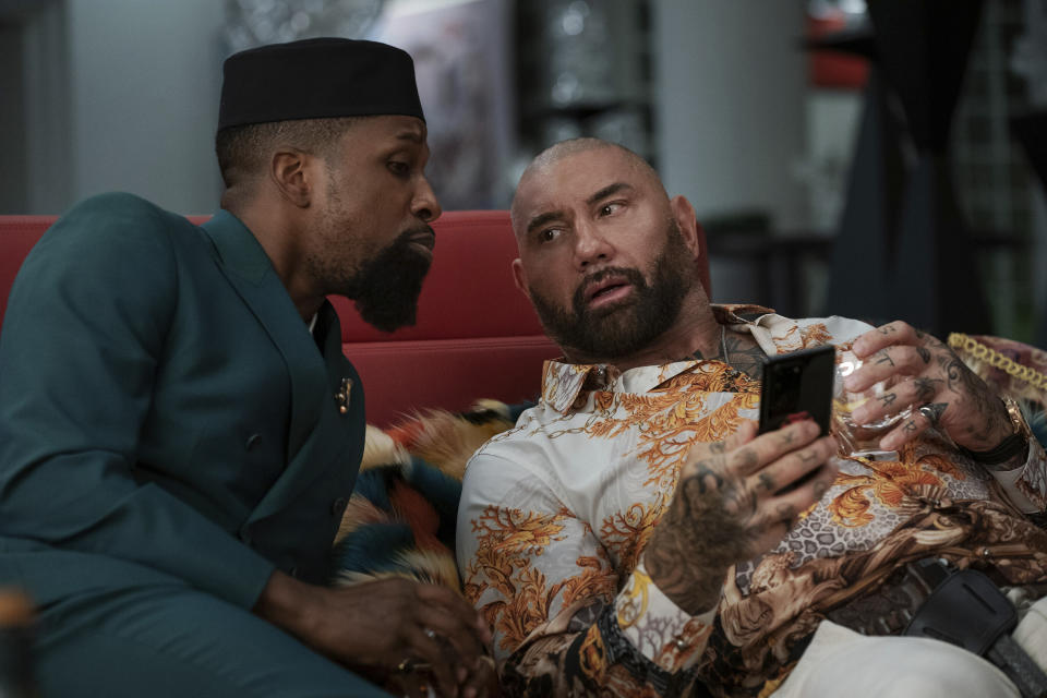 This image released by Netflix shows Leslie Odom Jr., left, and Dave Bautista in a scene from "Glass Onion: A Knives Out Mystery." (John Wilson/Netflix via AP)