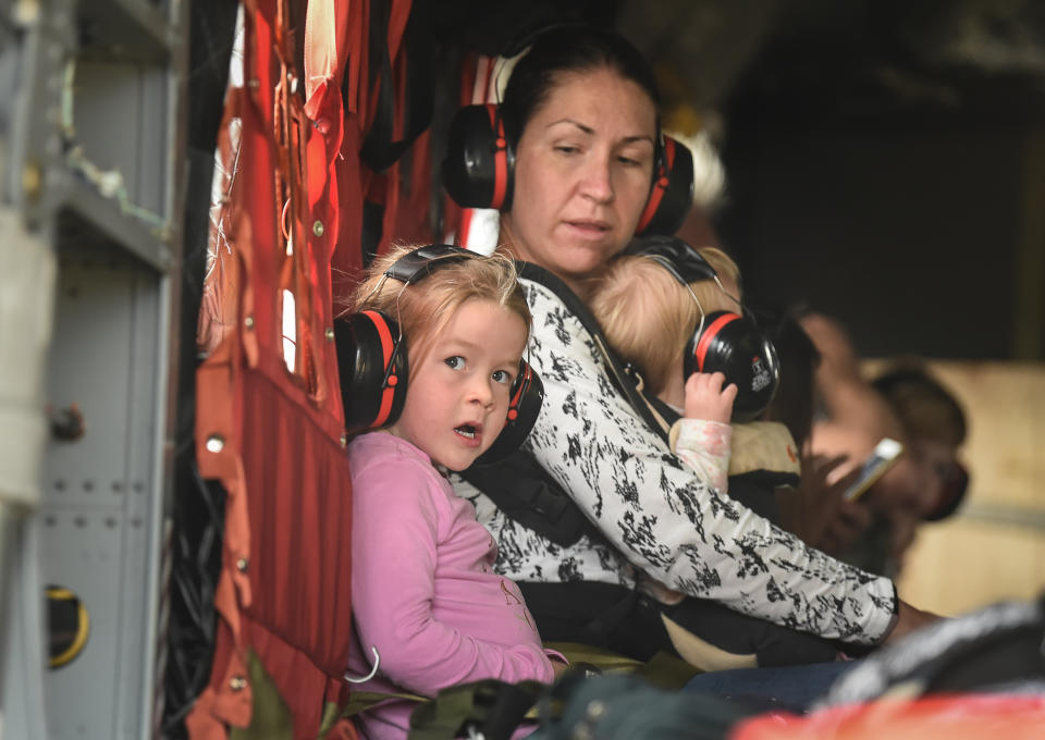 Families with small children and babies are evacuated by air from the Mallacoota Airport.