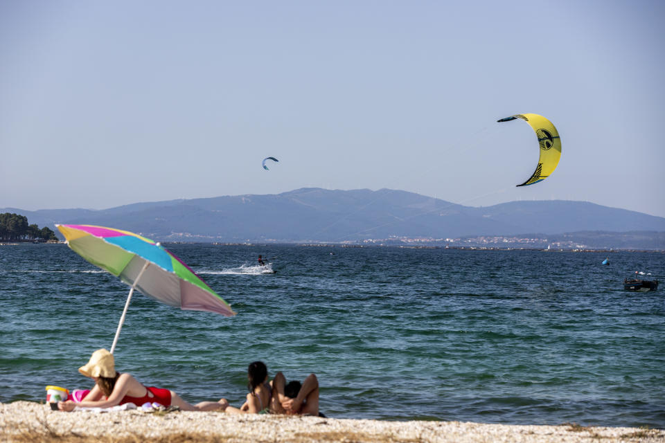 PONTEVEDRA, SPAIN - JULY 21: People practice windsurfing on the beach of O Bao on July 21, 2020 in Pontevedra, Spain. The island of Arosa, Arousa in the Galician language, has an area of approximately 7 square kilometers. It has 36 kilometers of coastline, of which 11 are beach, with fine white sand. It is one of the tourist destinations in Galicia with the most influx of visitors. (Photo by Xurxo Lobato/Getty Images)