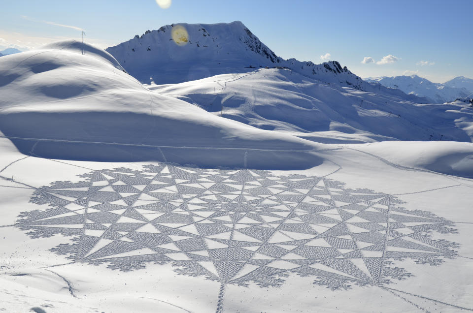 In this 2014 photo, provided by Simon Beck Snow Art, is one of Beck's pieces in the snow at the Les Arcs ski resort in southeastern France. Using a compass, snowshoes and his background as a cartographer and competitive orienteer, the 61-year-old British artist and a handful of volunteers recently tromped across the frozen reservoir near Silverthorne, Colo., a resort town west of Denver, to create a massive, geometrical design on a fresh canvas of snow. (Simon Beck Snow Art via AP)