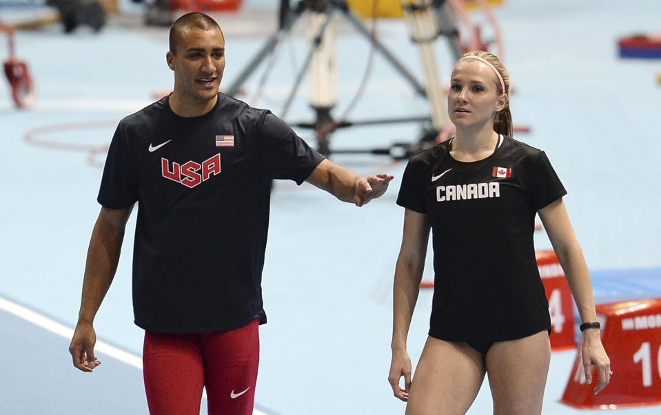 United States' Ashton Eaton, left, talks to his wife Canada's Brianne Theisen Eaton as they compete in the heptathlon and pentathlon during the Athletics Indoor World Championships in Sopot, Poland, Friday, March 7, 2014. (AP Photo/Alik Keplicz)