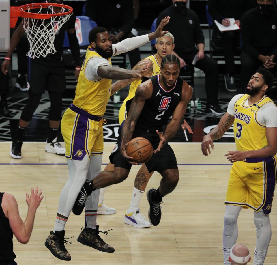 Clippers' Kawhi Leonard passes off in-between Lakers' Andre Drummond, Kyle Kuzma and Anthony Davis.