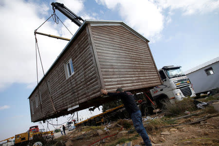 FILE PHOTO: A man helps direct the removal of a pre-fabricated home in the recently evicted illegal Israeli settler outpost of Amona, in the occupied West Bank February 6, 2017. REUTERS/Baz Ratner/File Photo