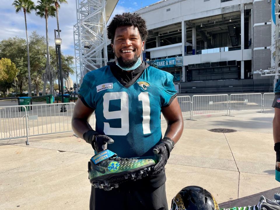 Dawuane Smooth displays the cleats he will wear on Sunday, honoring the Better Dads Society.