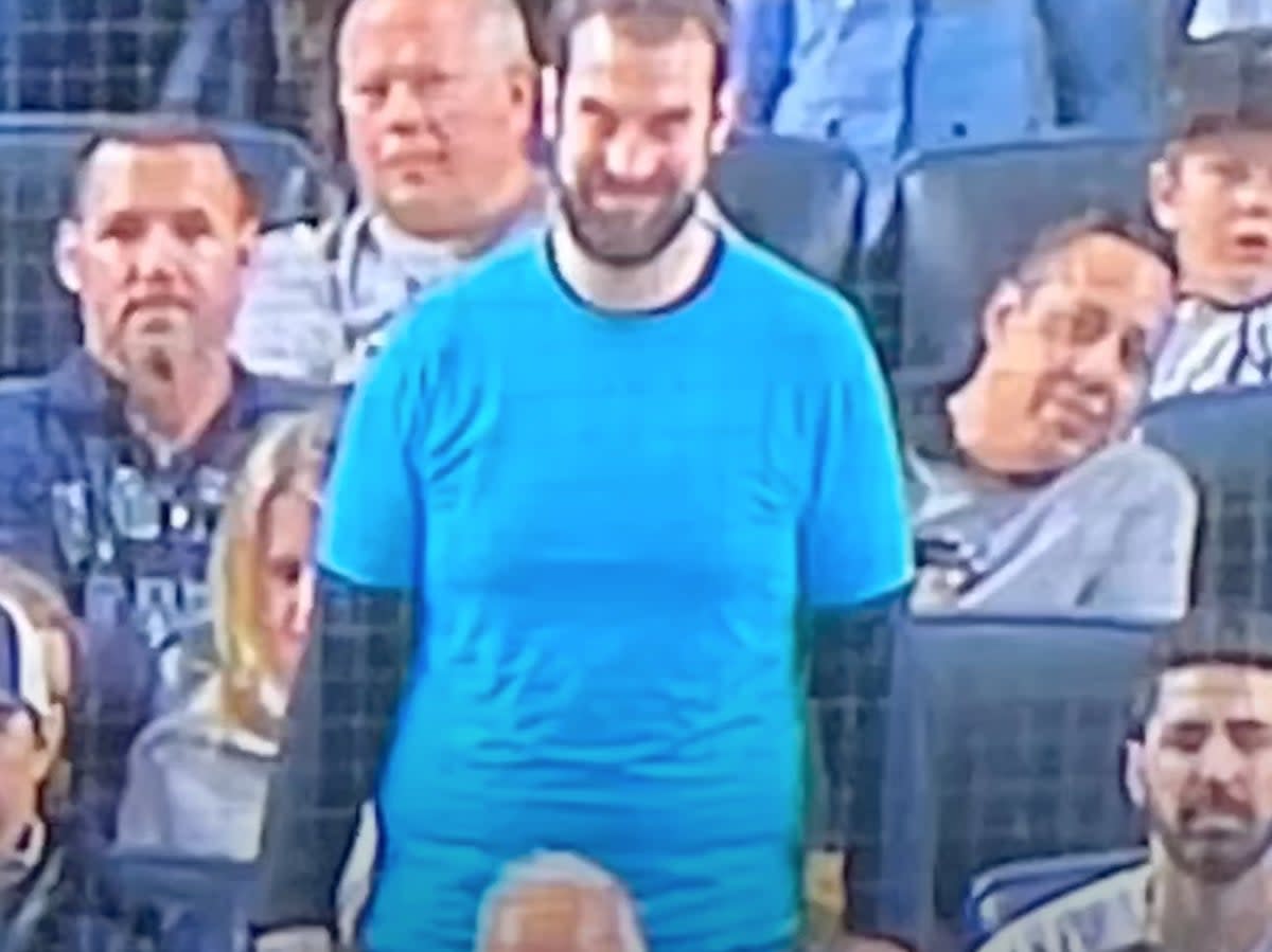 An actor promoting the Paramount Pictures horror film “Smile” in the background of a baseball game (screengrab/YouTube/Last Ditch Sports)