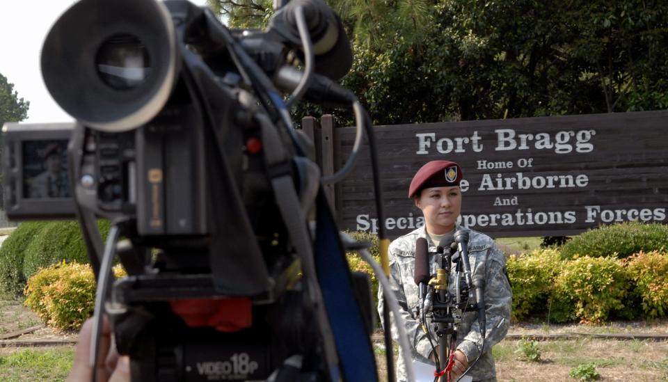 Then-public affairs officer Maj.  Angela Funaro from the 18th Airborne Corps conducts a press conference at one of the entrances to Fort Bragg.