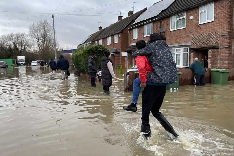 Residents wade through flood water in Loughborough, Leicestershire, after rain and strong winds from Storm Henk lashed large parts of the UK (PA Wire)