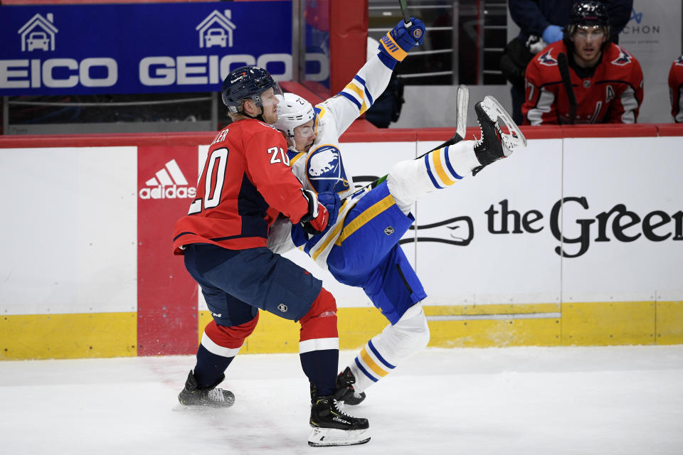 Washington Capitals center Lars Eller (20) battles with Buffalo Sabres center Curtis Lazar, right, during the third period of an NHL hockey game, Friday, Jan. 22, 2021, in Washington. (AP Photo/Nick Wass)