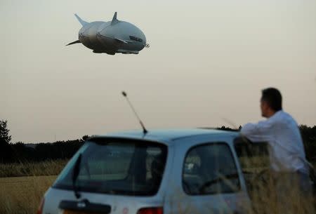 A man watches the Airlander 10 hybrid airship makes its maiden flight at Cardington Airfield in Britain, August 17, 2016. REUTERS/Darren Staples