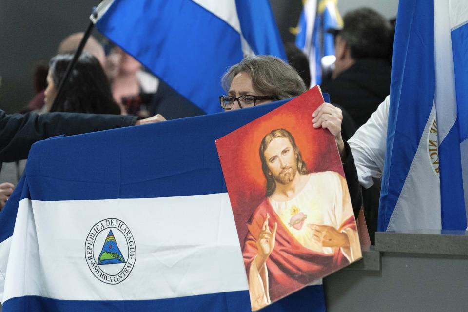 Supporters of Nicaraguan political prisoners chant at Washington Dulles International Airport, in Chantilly, Va., on Thursday, Feb. 9, 2023. Some 222 inmates considered by many to be political prisoners of the government of Nicaraguan President Daniel Ortega arrived at Washington after an apparently negotiated release. (AP Photo/Jose Luis Magana)