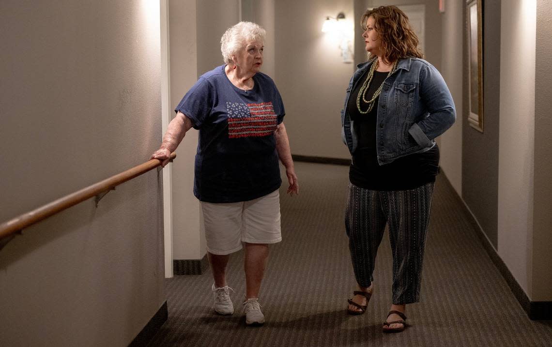 Jeannine Binder, left, and end-of-life doula Ashley Boydston stroll the hallways of Binder’s condo building. Binder’s family asked Boydston to continue to visit her after her husband died in April. Nick Wagner/nwagner@kcstar.com