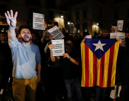 Protesters hold up signs reading " Freedom Political Prisoners, Sanchez Cuixart" outside the regional government headquarters after Spain's High Court jailed the leaders of two of the largest separatist organizations, the Catalan National Assembly's Jordi Sanchez and Omnium's Jordi Cuixart, in Barcelona, Spain, October 16, 2017. REUTERS/Gonzalo Fuentes