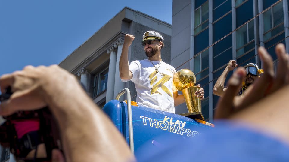 Thompson celebrates with the Larry O'Brien trophy during the Warriors' NBA Championship parade in 2022. - John Hefti/AP