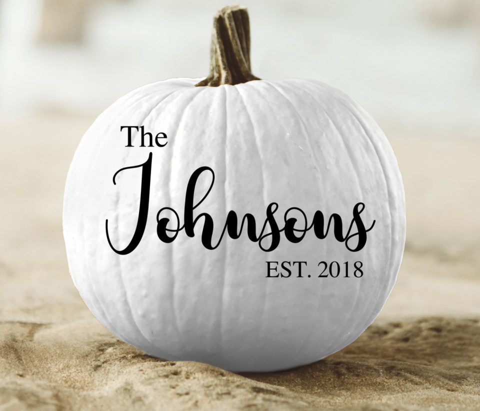 white pumpkin with family last name written on it