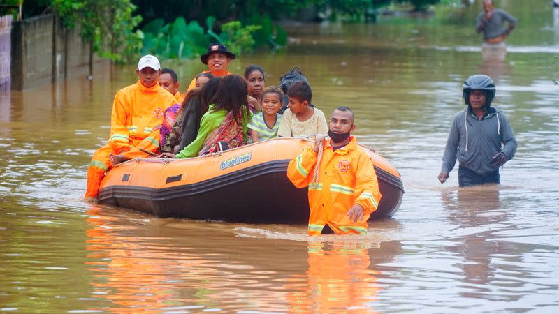 Trabajadores de rescate evacuan a personas a través del agua en una zona afectada por las inundaciones tras las fuertes lluvias en Dili, Timor Oriental, 4 de abril de 2021. REUTERS/Lirio da Fonseca