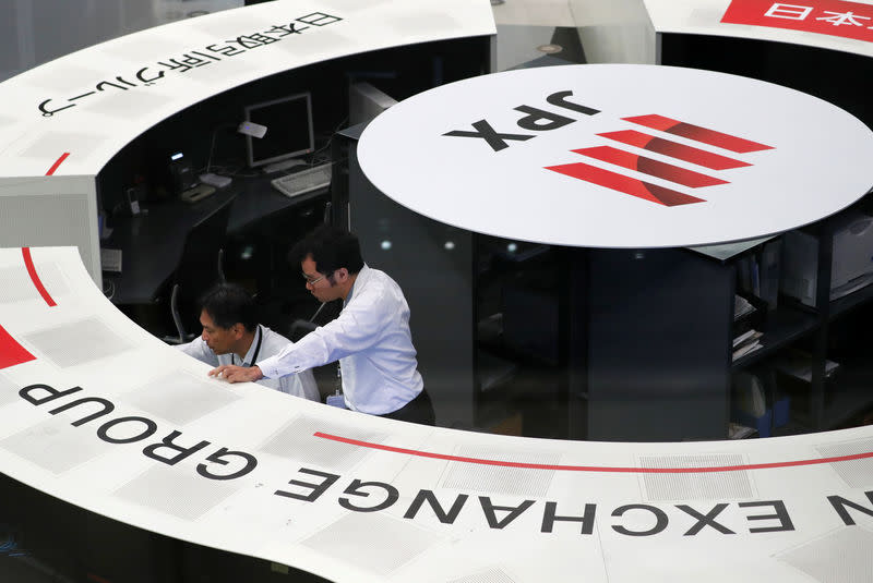 FILE PHOTO: Employees of the Tokyo Stock Exchange (TSE) work at the bourse in Tokyo Japan, October 11, 2018. REUTERS/Issei Kato