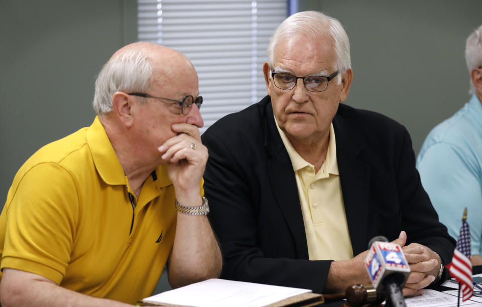 Board of County Commissioners chairman Ed Eilert talks with 1st District Commissioner Ron Shaffer, left, during the Johnson County Board of Canvassers meeting, Monday, Aug. 13, 2018, in Olathe, Kan. County election officials across Kansas on Monday began deciding which provisional ballots from last week's primary election will count toward the final official vote totals, with possibility that they could create a new leader in the hotly contested Republican race for governor. Secretary of State Kris Kobach led Gov. Jeff Colyer by a mere 110 votes out of more than 313,000 cast as of Friday evening. (AP Photo/Charlie Neibergall)