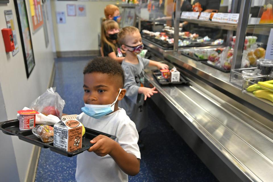 Kindergartner Kyree Thompson, 5, takes his lunch tray and heads to his table in the cafeteria at Joanna Connell Elementary School in Erie on Oct. 8. Erie School District officials have said they would reinstate an indoor face mask mandate at its buildings if Erie County reached a high COVID-19 Community Level, which it did Thursday evening.