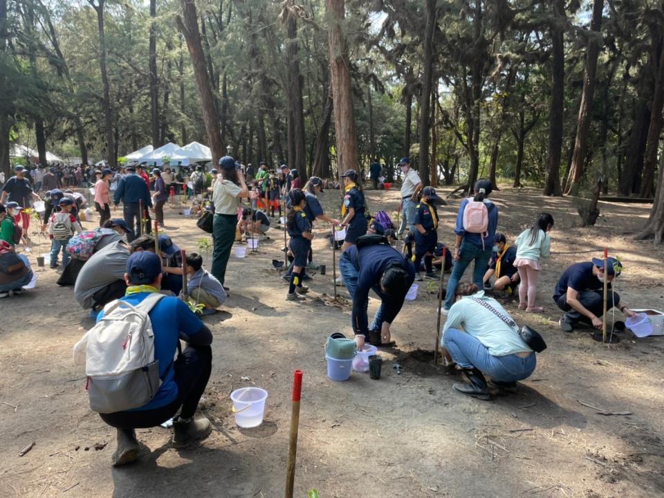 南市植樹節活動十一日登場，大小朋友在漁光島保安林區栽植台灣原生濱海植物。（農業局提供）