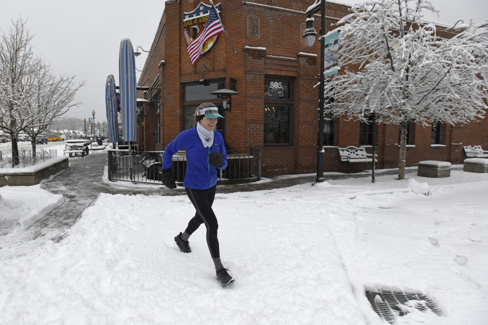 Local runner Jenelle Potvin goes on her daily jog along Bridge Street on Friday, March 1, 2024, in Truckee, Calif. The most powerful Pacific storm of the season is forecast to bring up to 10 feet of snow into the Sierra Nevada by the weekend (AP Photo/Andy Barron)