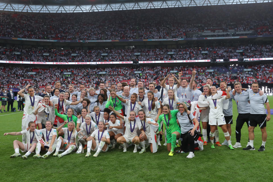 The England team pose for a photo in front of a packed Wembley stadium after winning the UEFA Women's Euro England 2022 final.