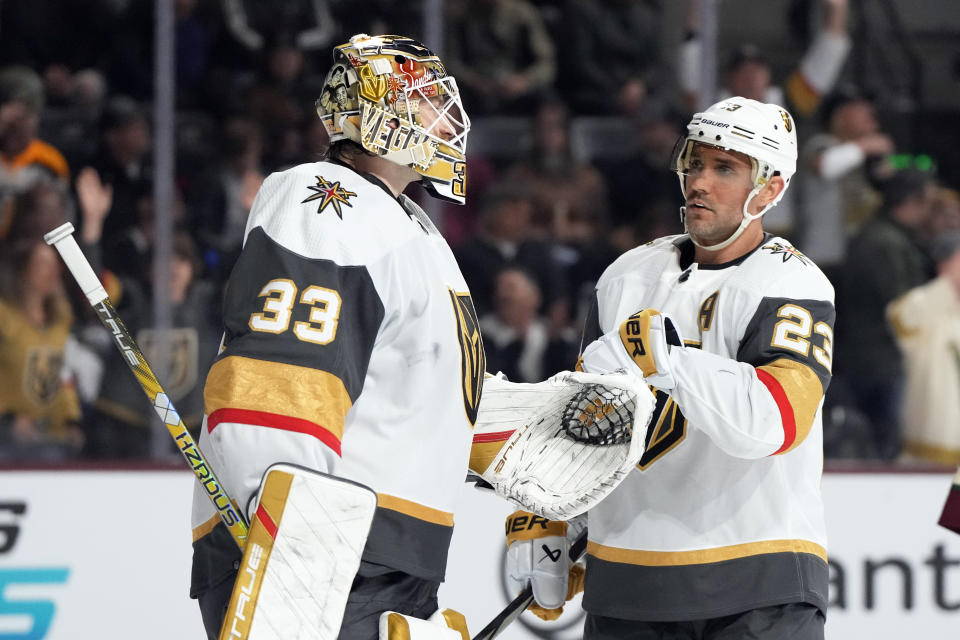 Vegas Golden Knights defenseman Alec Martinez (23) celebrates with goaltender Adin Hill after the team's win over the Arizona Coyotes in an NHL hockey game Thursday, Feb. 8, 2024, in Tempe, Ariz. (AP Photo/Rick Scuteri)