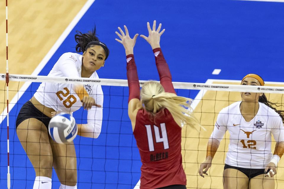 Texas' Kayla Caffey spikes the ball against Louisville's Anna DeBeer during the first set of Saturday night's UT sweep in the NCAA volleyball national championship match. It was the Longhorns' third NCAA title.