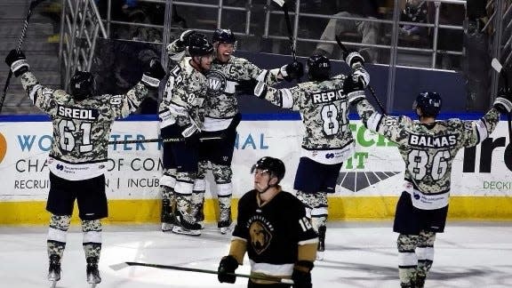 Worcester Railers players celebrate a goal during Saturday's game while wearing their alternate uniforms to celebrate Military Appreciation Night.