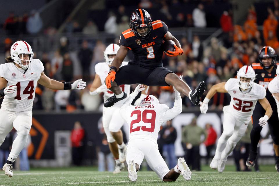 Oregon State Beavers running back Deshaun Fenwick (1) jumps over Stanford Cardinal cornerback Terian Williams (29) during the second half at Reser Stadium Nov. 11 in Corvallis.