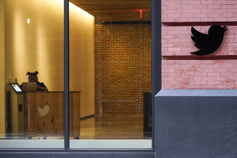 A receptionist works in the lobby of the building that houses the Twitter office in New York, Wednesday, Oct. 26, 2022. Elon Musk posted a video Wednesday showing him strolling into Twitter headquarters ahead of a Friday deadline to close his $44 billion deal to buy the company. (AP Photo/Mary Altaffer)