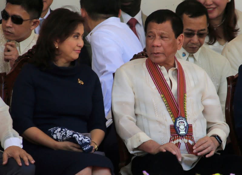 FILE PHOTO - President Rodrigo Duterte talks to Vice-President Leni Robredo during the Philippine National Police Academy graduation ceremony in Camp Castaneda