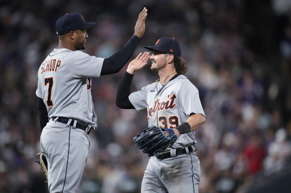 Detroit Tigers third baseman Jonathan Schoop, left, and left fielder Zach McKinstry meet after the team's baseball game against the Colorado Rockies on Saturday, July 1, 2023, in Denver. (AP Photo/David Zalubowski)