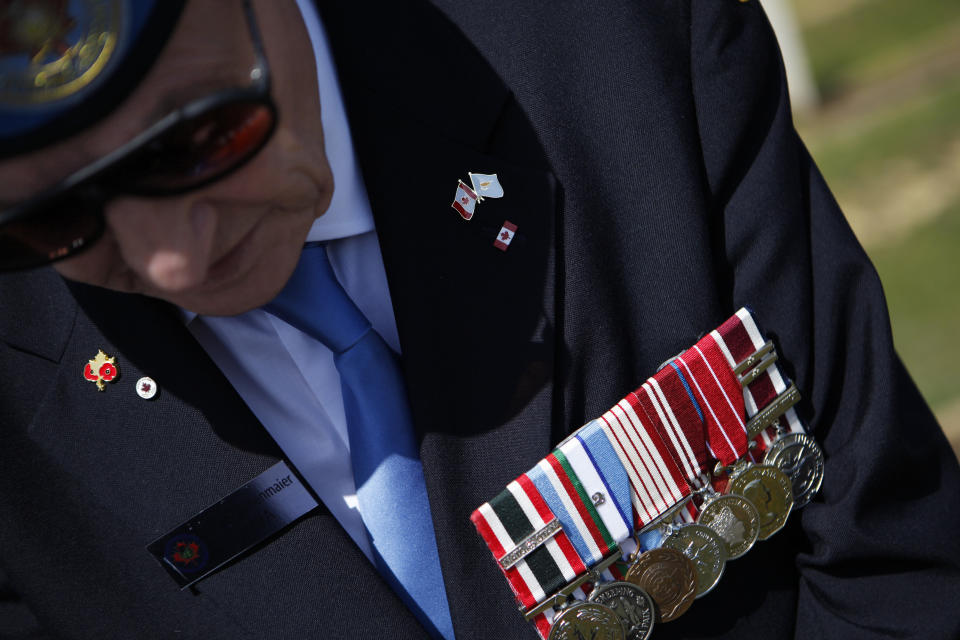 Canadian veteran soldier Edward Widenmaier, who served with the United Nations Peacekeeping force on war-divided Cyprus displays his medals at a cemetery for fallen Canadian and British soldiers inside the UN-controlled buffer zone on the outskirts of the capital Nicosia on Tuesday, March 18, 2014. Thousands of soldiers from 32 countries have donned the UN blue beret in Cyprus over half a century in what has become the longest serving peacekeeping force of its kind. Some 178 lost their lives there. (AP Photo/Petros Karadjias)