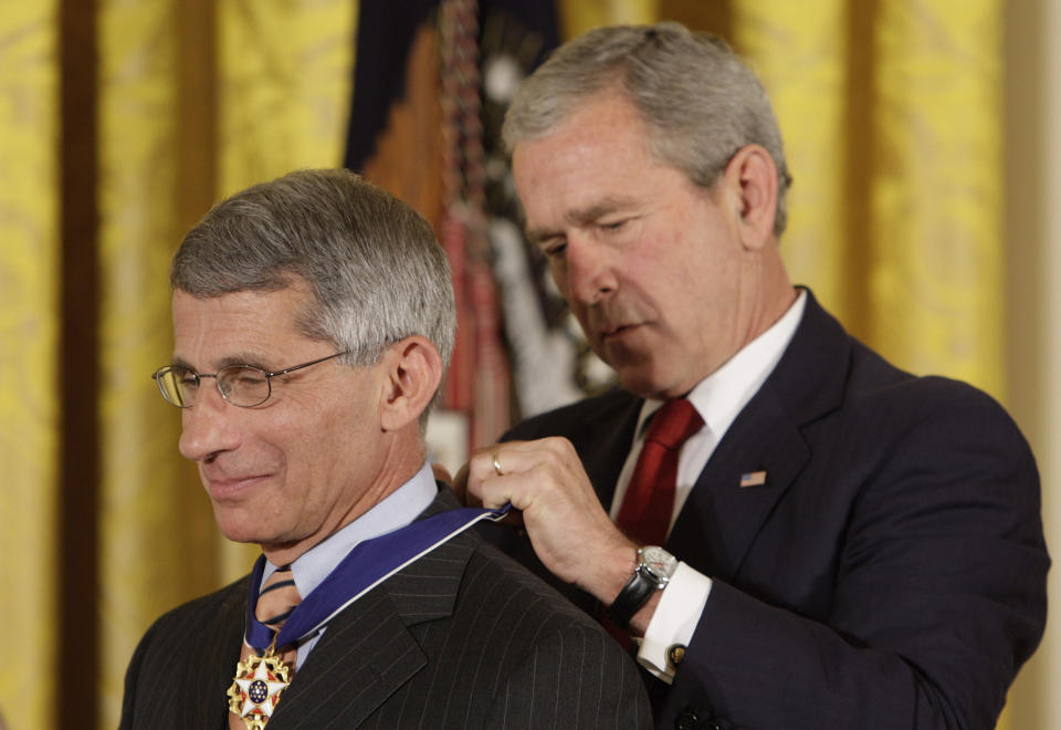 FILE - President Bush places the Presidential Medal of Freedom on Dr. Anthony S. Fauci, director of the National Institute of Allergy and Infectious Diseases, as he takes part in a ceremony for the 2008 recipients of the Presidential Medal of Freedom, June 19, 2008, in the East Room at the White House in Washington. Fauci steps down from a five-decade career in public service at the end of the month, one shaped by the HIV pandemic early on and the COVID-19 pandemic at the end. (AP Photo/Ron Edmonds, File)