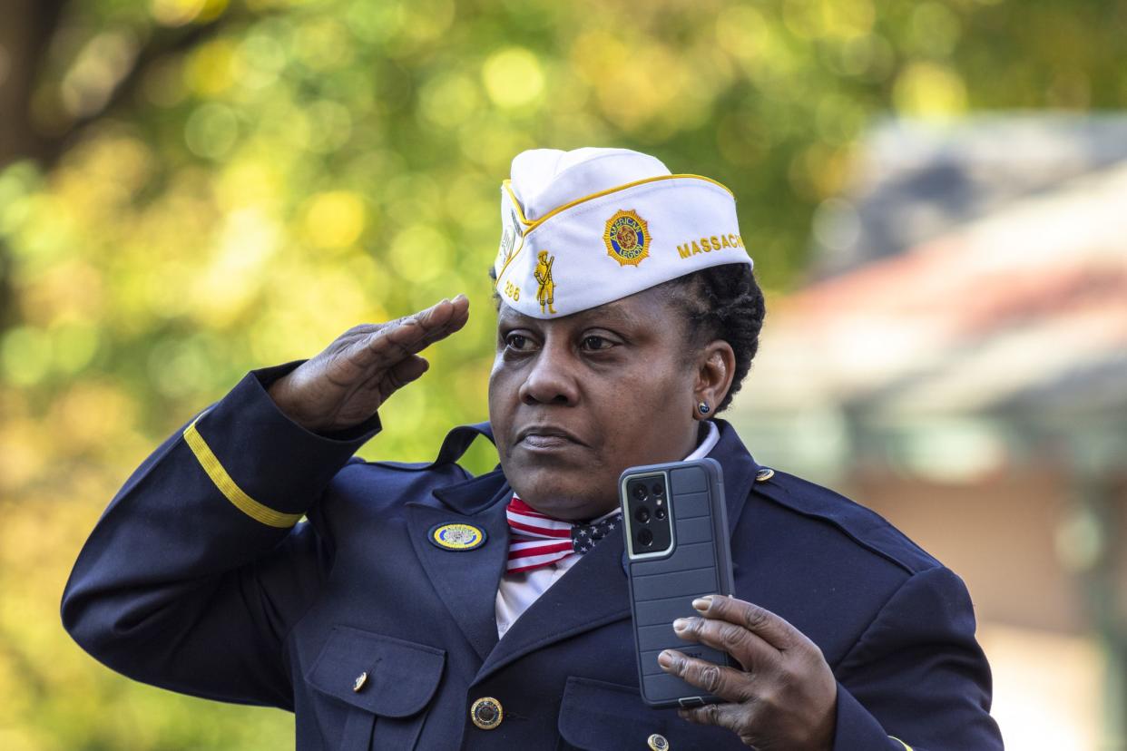 A woman stands at salute during the Veterans Day Parade in Boston