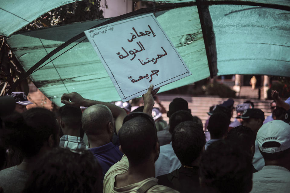 People stage a demonstration outside a court in solidarity with detained journalist Hajar Raissouni, in Rabat, Morocco, Monday, Sept. 9, 2019. Banner in Arabic reads "Free Hajar" and "Aborting our freedoms by the state is a crime". (AP Photo/Mosa'ab Elshamy)