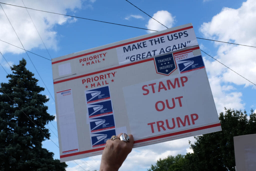 A activists holds a USPS envelope while protesting Donald Trump’s visit on August 17, 2020 in Oshkosh, Wisconsin. (Photo by Alex Wroblewski/Getty Images)