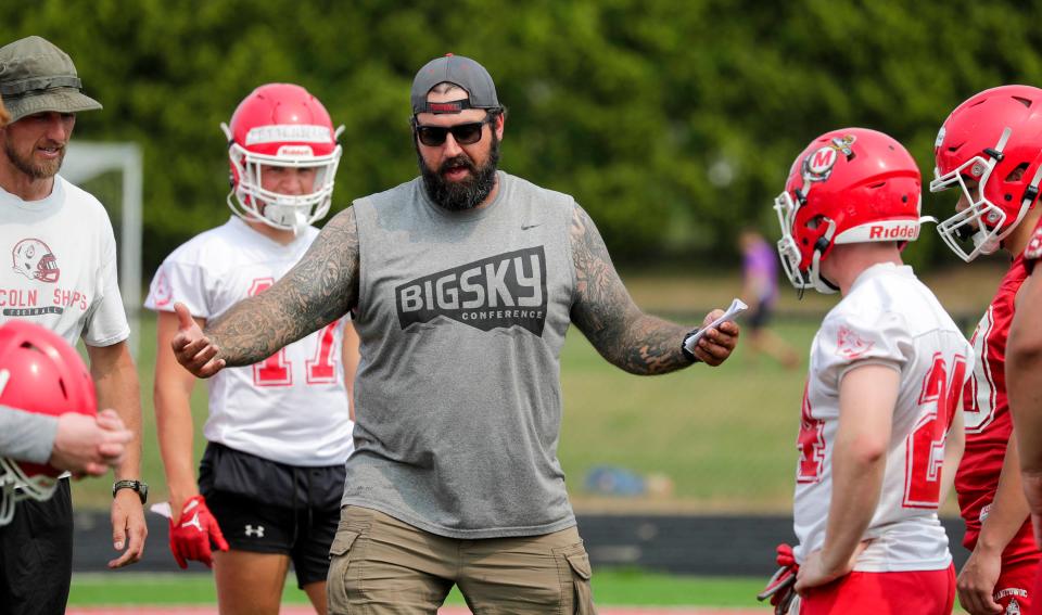 Manitowoc Lincoln offensive line coach and former Green Bay Packers player Evan Smith emphasizes a skill to players at practice at Ron Rubick Field on Aug. 1 in Manitowoc.