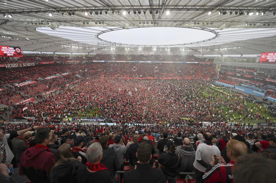Aficionados del Bayer Leverkusen celebran después de que el equipo confirmó el título de la Bundesliga con la victoria ante Werder Bremen el domingo 14 de abril del 2024. (David Inderlied/dpa via AP)