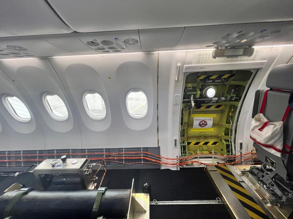 Inside the 737 MAX jet showing the exit door and a black tank