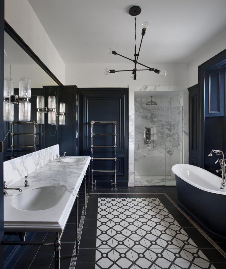 A bathroom with wall sconces and a ceiling light